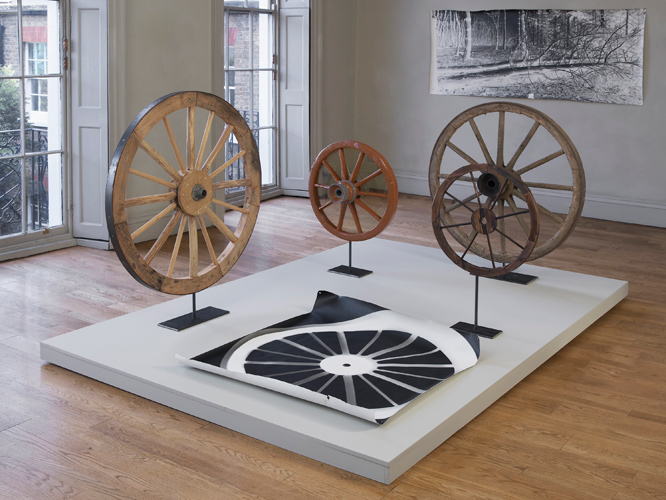 A Circle, image: foreground:  Rupert Ackroyd + David Gates 'Cart Wheel Exercise' 2014, a group of 5 works as follows: (i) 112 cm dia, oak, elm, steel on steel base, (ii) 70 cm dia, perspex, oak, ash, elm, paint, steel on steel base, (iii) 111 cm dia, pine, chestnut, steel on steel base, (iv) 60 cm dia, pine, steel on steel base, (v) 106 × 120 cm, unique photogram on paper, base: 200 × 300 cm, mdf, pine, paint; background left: David Gates 'Standard Image #03' unique photograph 89 × 218 cm / 35 × 85.8 in (approx) 2014; installation photography by Andy Keate
